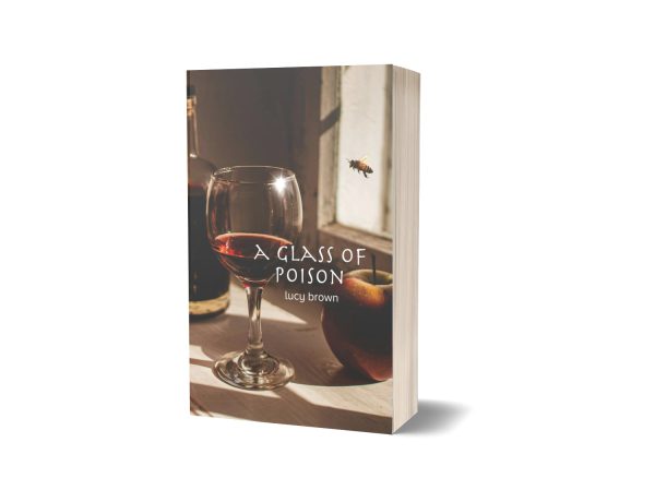 A book titled "A Glass of Poison" by Lucy Brown. The cover features a glass of red wine, a bottle, and an apple on a wooden surface near a window. A fly is hovering above the apple. The scene is lit with natural light creating a warm ambiance. The book is standing upright. BookSelf Book Cover Design & Premade Book Covers
